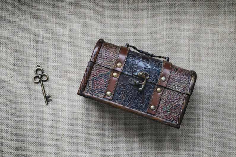 Vintage loot box and key on sackcloth background .