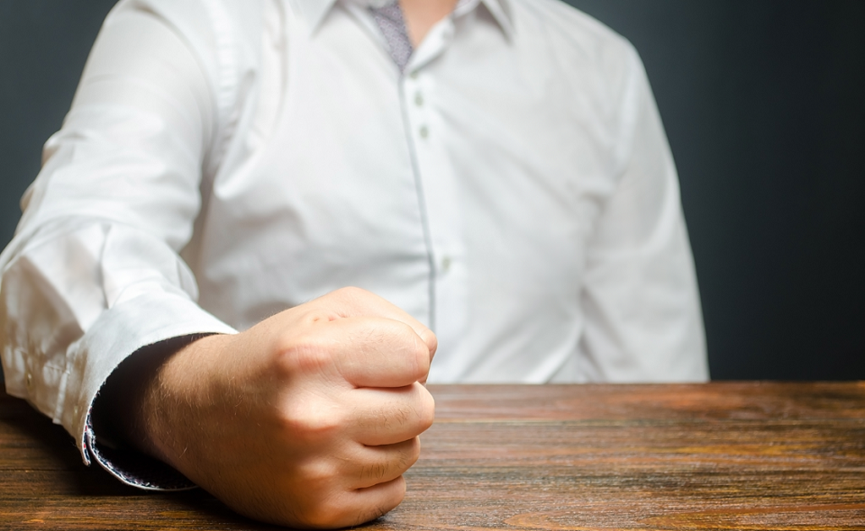 man slamming fist on table